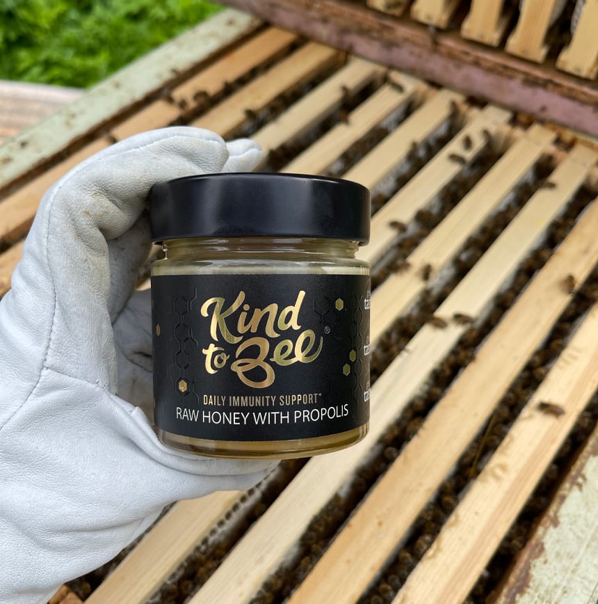 Beekeeper is holding a jar of propolis honey